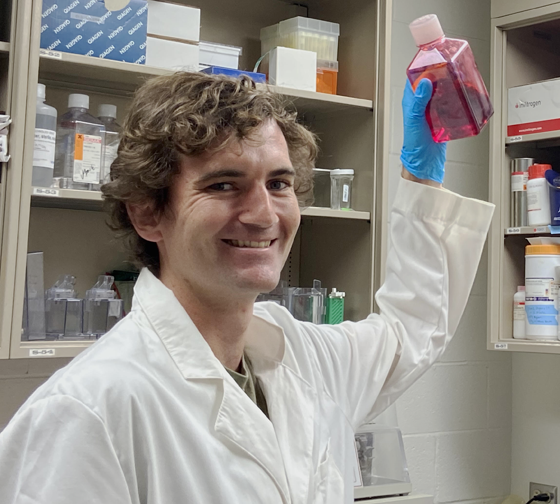 Hayden holding a bottle in his lab.