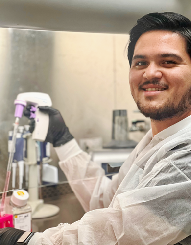 Lance holding a pipetter in his lab.